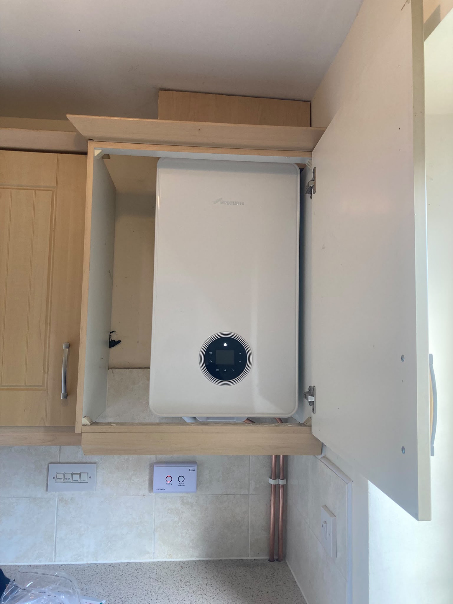 Worcester boiler fitted in a kitchen wall cupboard